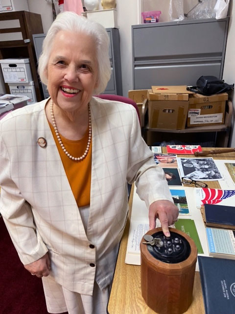 Phyllis Bridges with Sarah Weddington's wooden voting device from the Texas Legislature