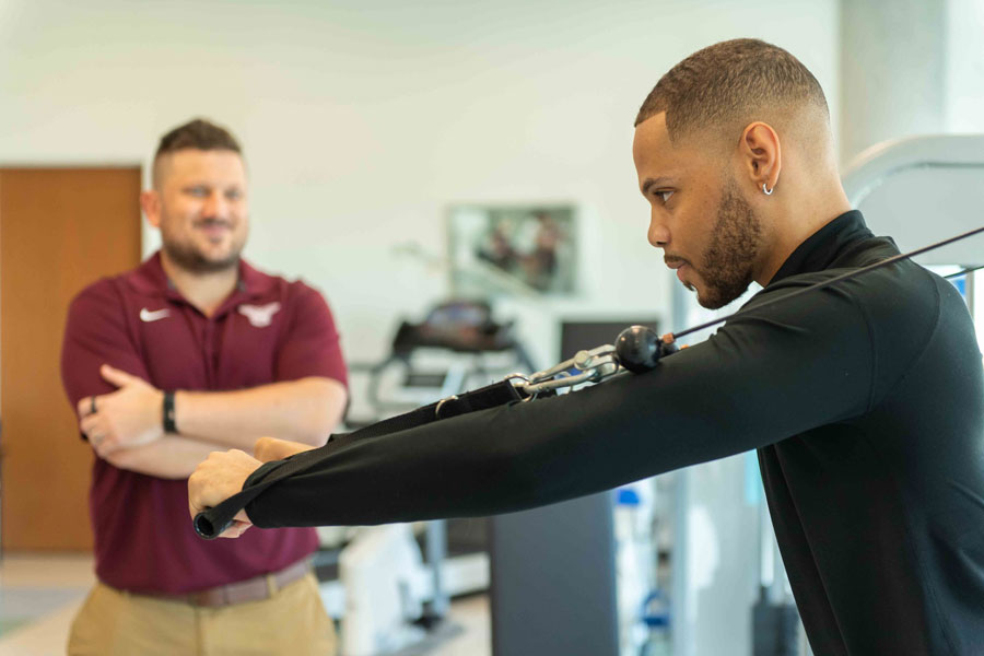 An athlete works out with a TWU sports nutritionist instructs and guides them.