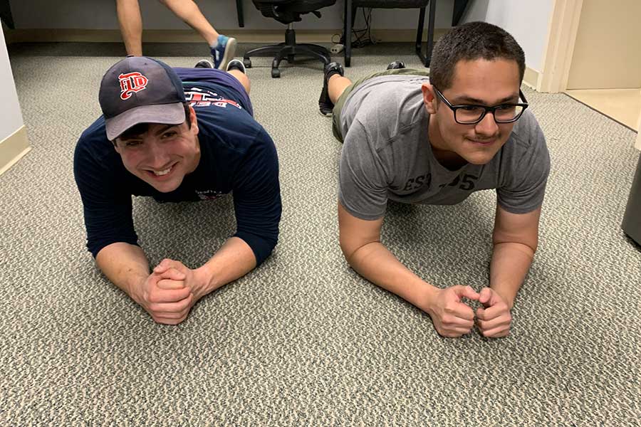 two firefighters hold planks on the ground