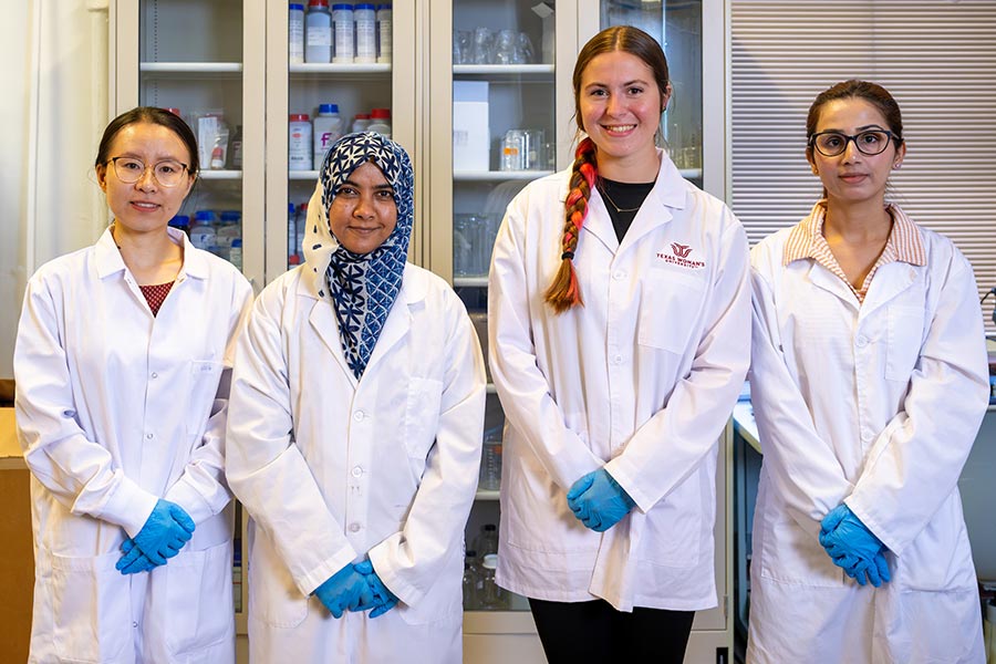 Dr. Wang stands next to three nutrition students