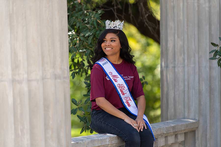 Aryana Bosh sits on ledge with crown and sash