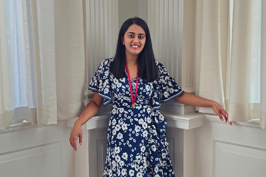 Kashish Venaik leaning against a white pillar indoors