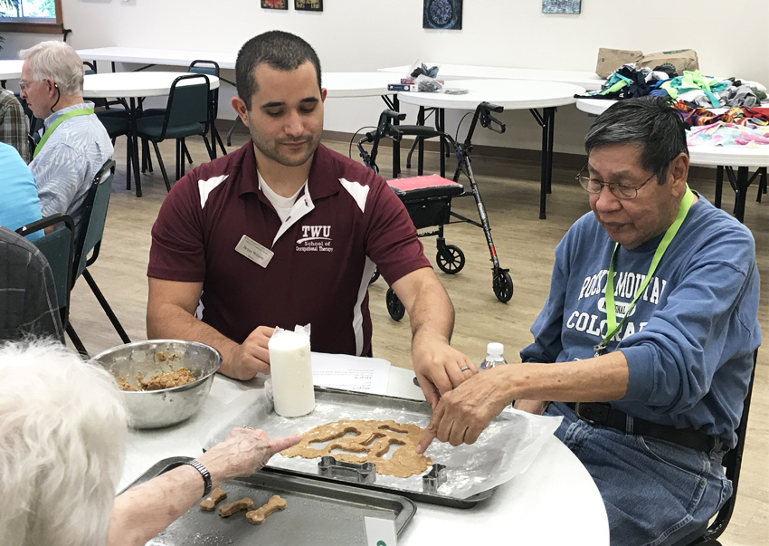 OT student works with adult patients on cookie cutter project 