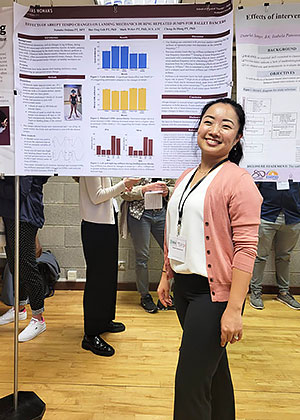 woman stands next to presentation poster