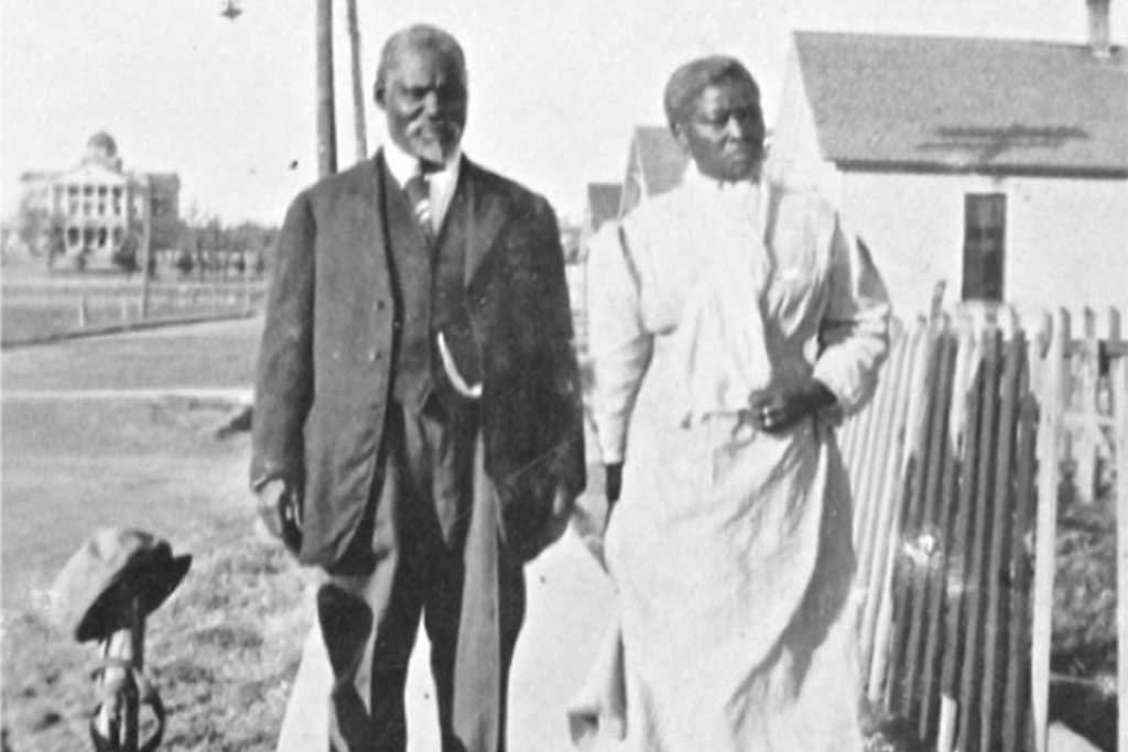 A black and white photo of an African American couple walking in Quakertown in Denton, TX.	