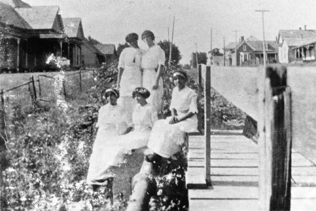 A black and white photo of a group of African American women outdoors in Quakertown in Denton, TX.	