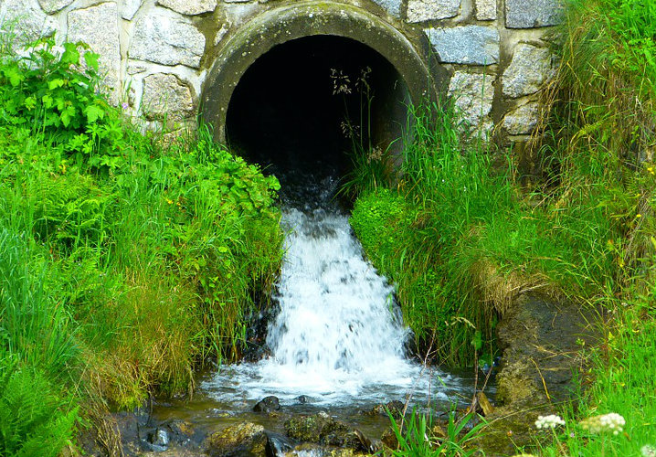 Stream of water coming out of a covert. 