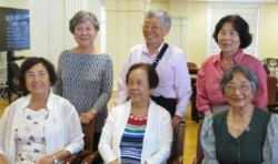 Six women smiling in a group photo.