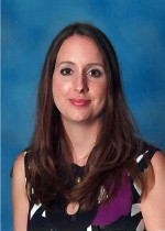 A photo of Jennifer Richey. She has long brown hair and is wearing a black and white dress.