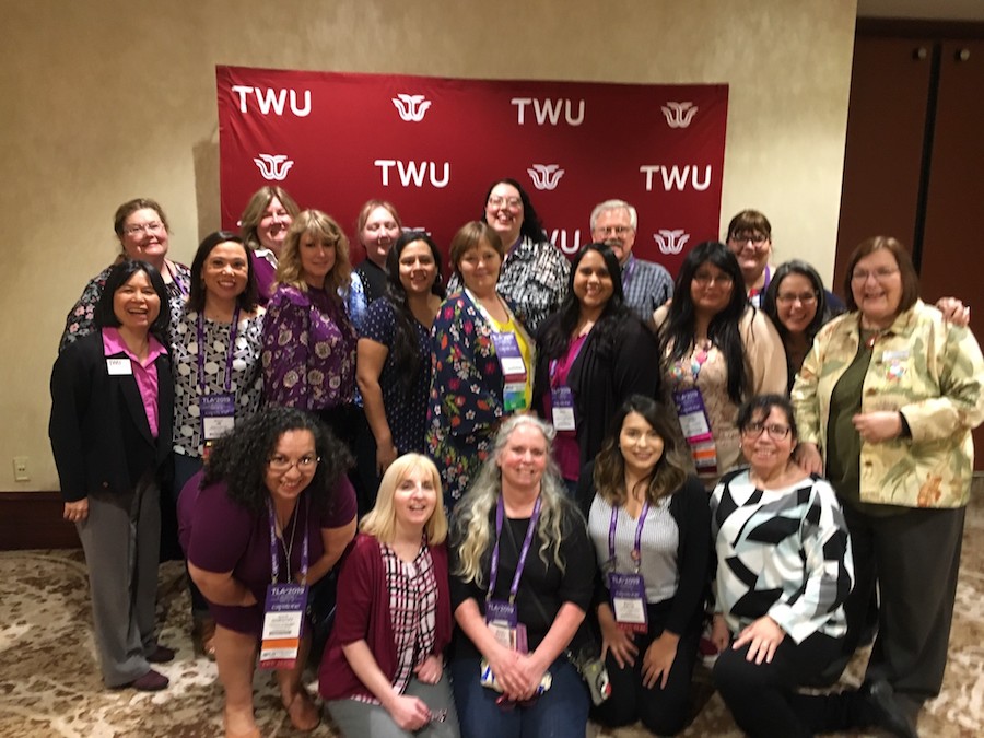 The TWU TLCART cohort members standing in front of a Texas Woman's banner.