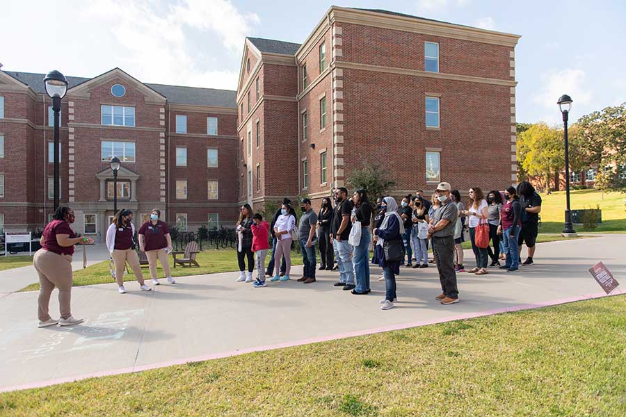 Prospective students take a campus tour near Parliament Village during a Pioneer Preview Day event.	