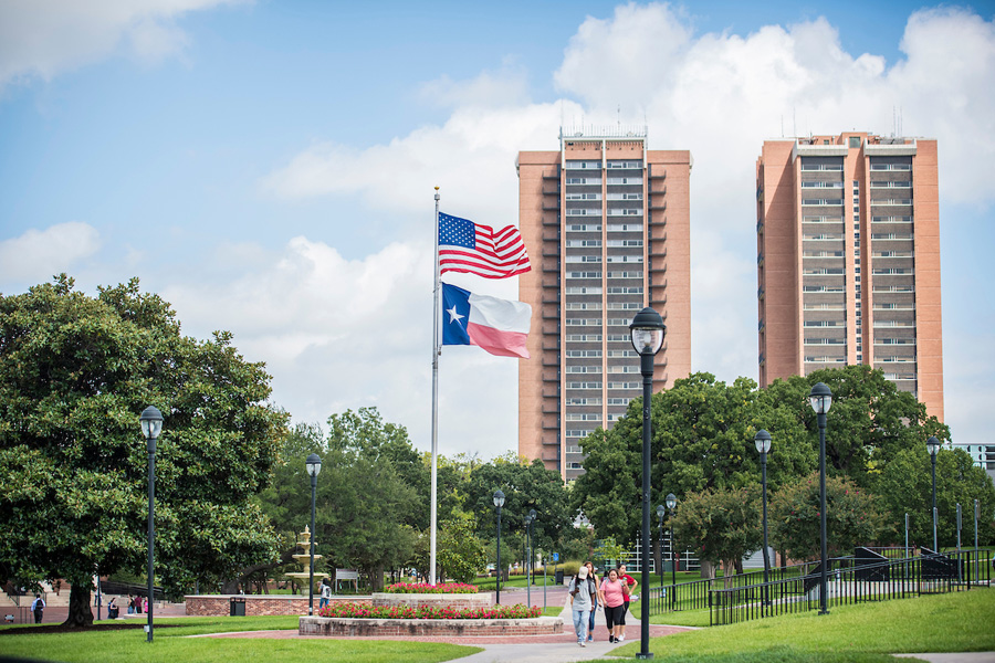 Close-up of the American and Texas flags flying in front of the dorms on TWU's Denton campus.
