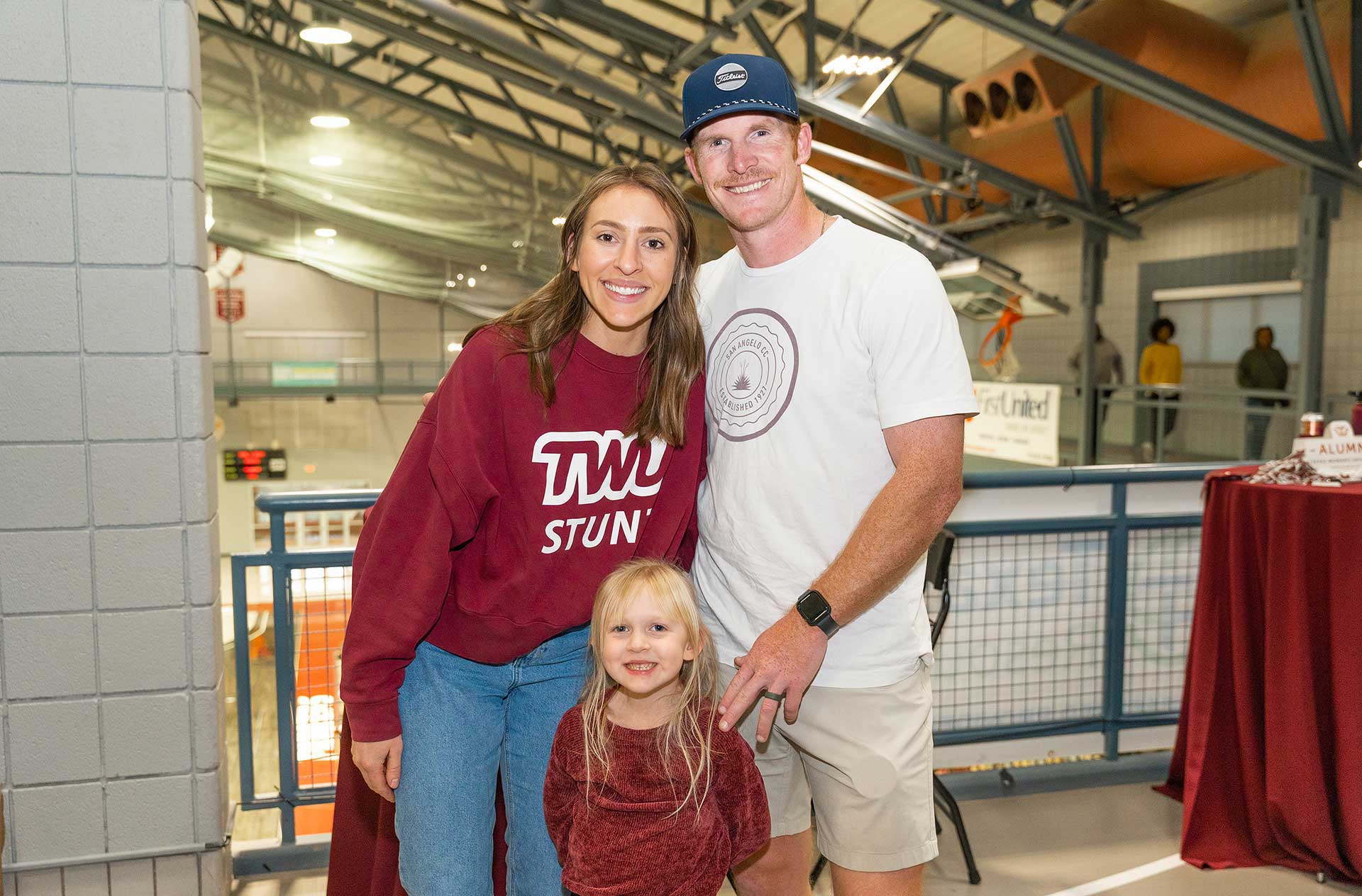 A family poses in a gymnasium