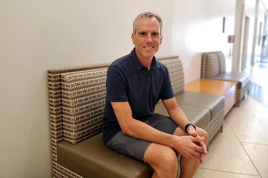 man sits on chair in hallway 