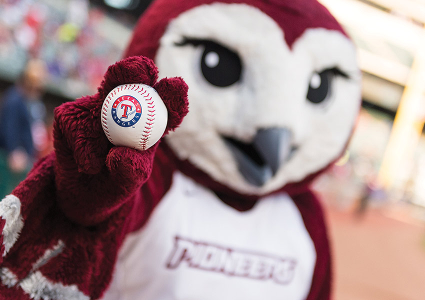 TWU's mascot, Oakley, holding a Texas Rangers baseball. 