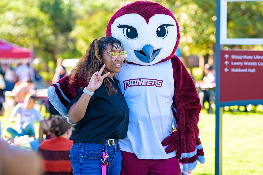 Oakley poses for a photo with a TWU student at an evening event.