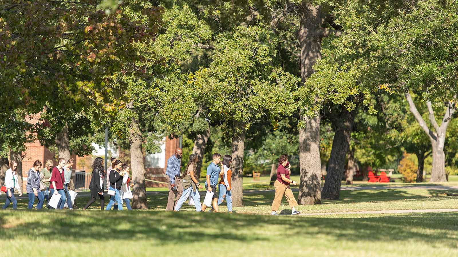 Prospective students walking with a tour group on the TWU Denton campus