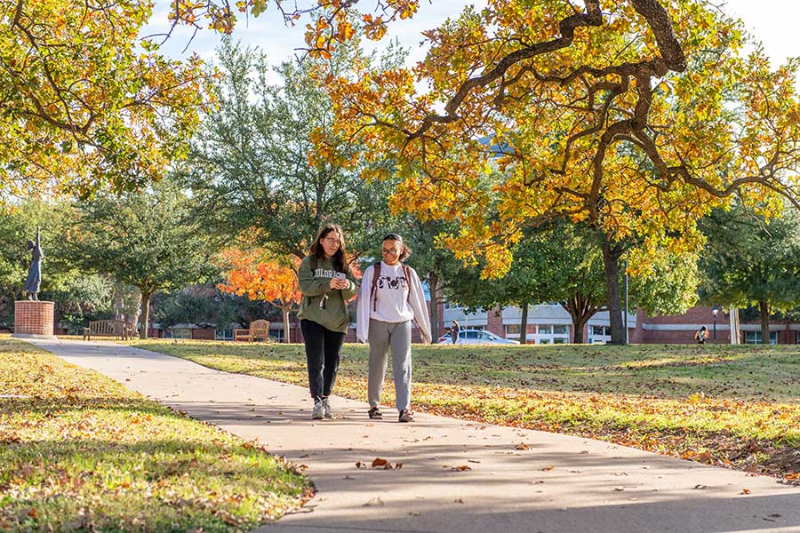 Two TWU students walk across campus on a Fall afternoon.