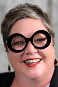 Headshot of Dr. Laura Lee McCartney. Woman with round, black frame glasses, smiling 