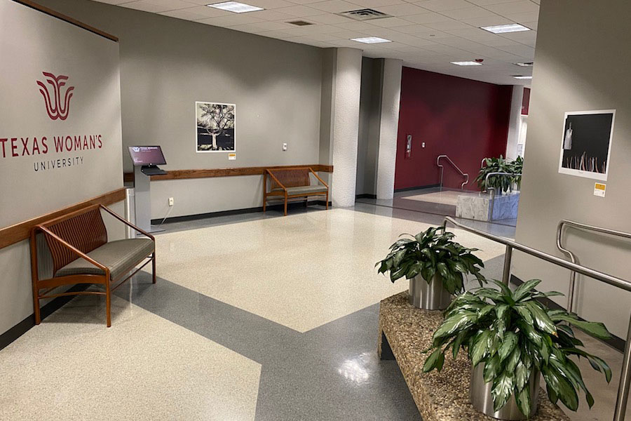 Two pieces of art from A Yellow Rose Project exhibition hang on the walls of ACT's 1st floor on the TWU Denton campus.