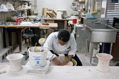 Student working at a pottery wheel